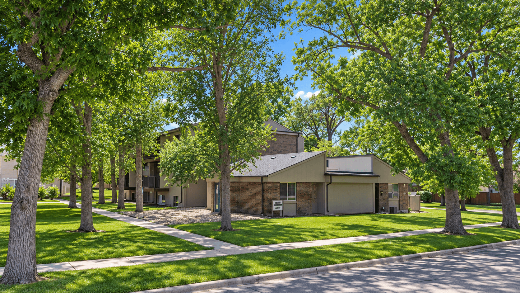 A house surrounded by green trees on a sunny day.